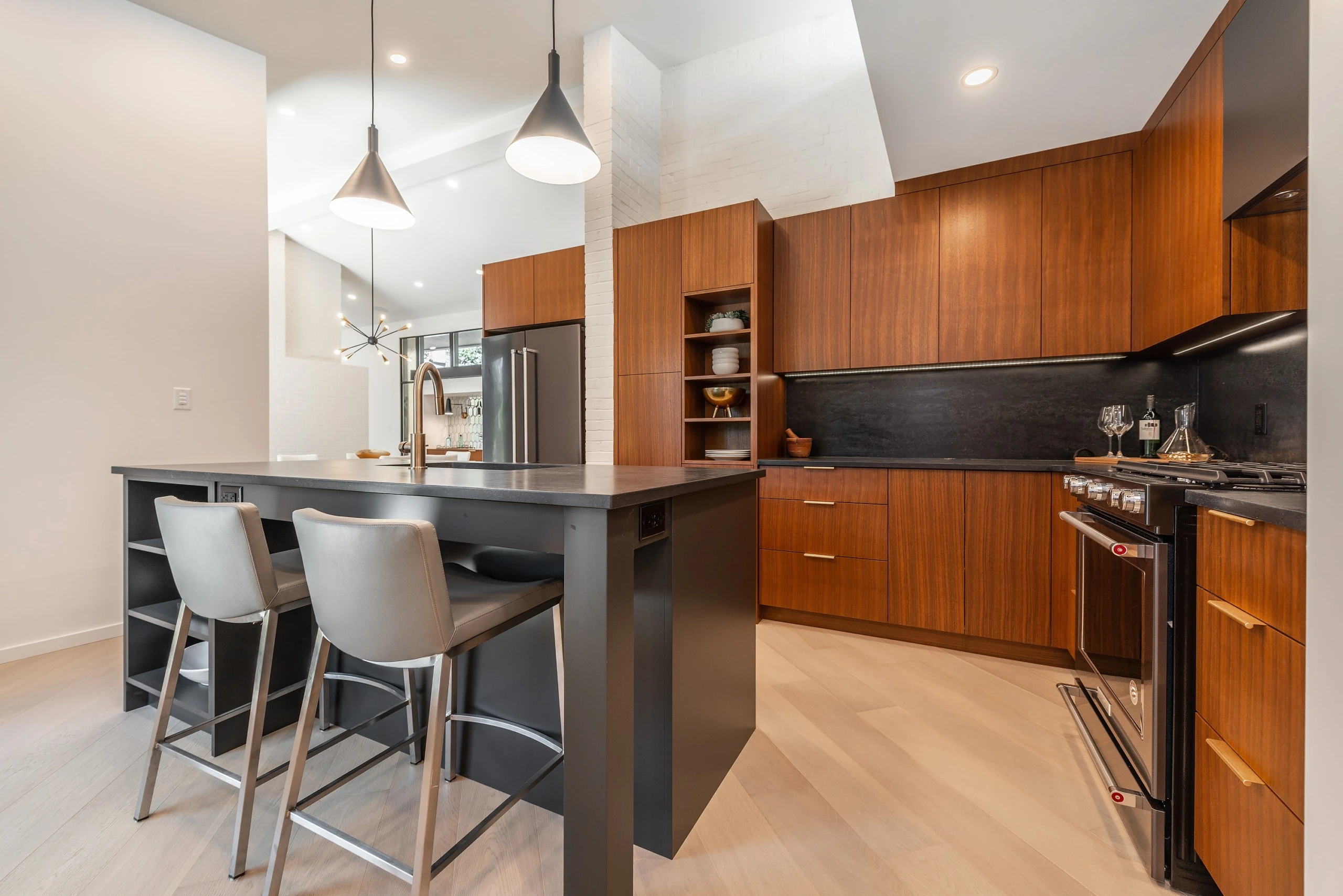 Modern Kitchen Contemporary kitchen featuring rich walnut cabinetry with dark island and integrated open shelving